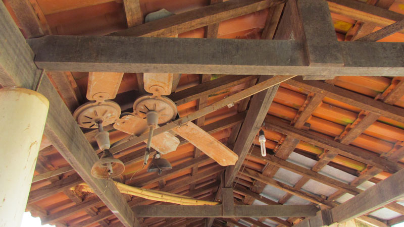 Ventiladores velhos pendurados nas vigas do telhado